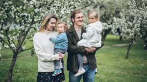 A family enjoying a spring day with blooming trees, capturing happiness and togetherness.